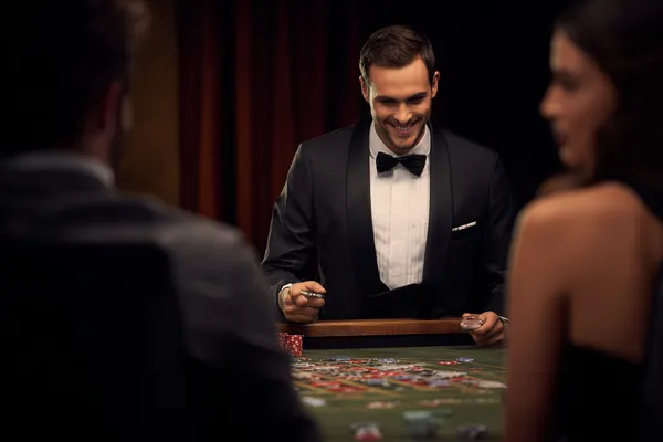 A woman in a luxurious green gown next to an ornate roulette wheel, capturing the upscale casino mood of BANGBEF.